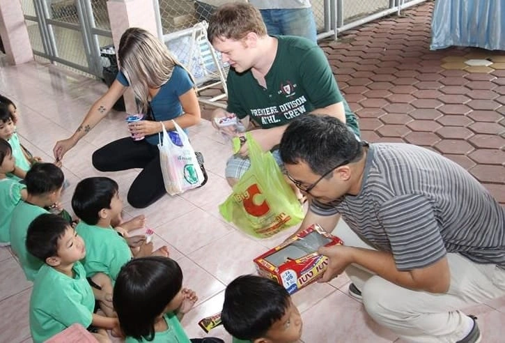 CMLocals Chiang Mai Locals Volunteer Non-O Visa volunteers distributing snacks and supplies to Thai school children